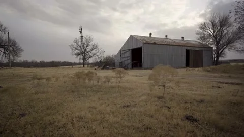 Low Angle Detriorated Abandon Barn in WIndy FIeld Dystopian Push in Shot from Stock-Footage 157500229