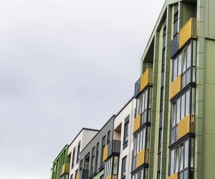 Low-angle diagonal view of a modern multi-colored apartment building row fe.. Stock Photos