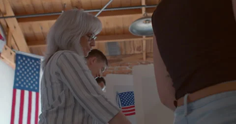 Low Angle of a diverse group of voters voting at a polling station Stock Footage 274930746