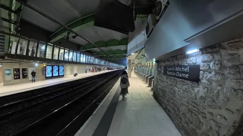Low-angle dolly forward at a modern metro station platform, with rails Stock Footage 334973223