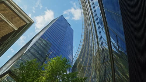 Low angle dolly movement between modern glass skyscrapers in business district Stock Footage 335731316
