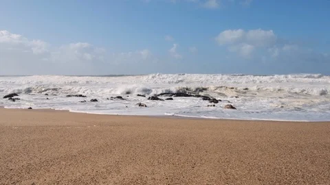 Low angle dolly shot along beach with rough, white waves. Slow motion. Vídeos de archivo 119295301