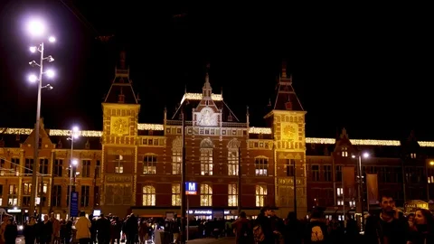 Low Angle Dolly Shot of Amsterdam Central Station at Night as Pedestrians 動画素材 105442633