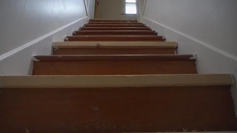 A low angle dolly shot POV view slowly walking up an old home's staircase. Stock Footage 122763664
