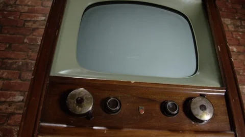 Low angle dolly sideways vintage television set on brick background Video stock 100612532
