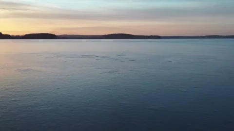 Low angle drone flight above calm lake during sunset Stock Footage 333830234