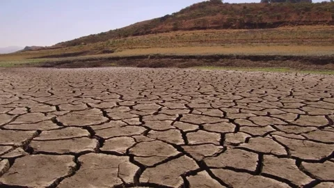 Low angle drone flight over cracked dry earth and parched lake bed Stock Footage 333484851