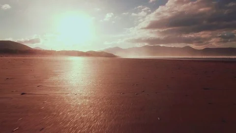 Low angle drone footage of beach and shore at sunset Stock Footage 70359523