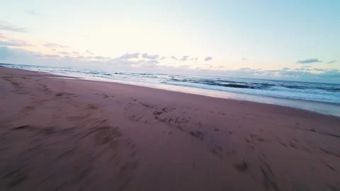 Low-angle drone footage of tidal stream merging with sea Stock Footage 340914916