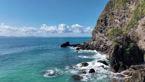 Low angle drone shot around the rocks as the tide hits them. Coast near a Vidéo 268029715
