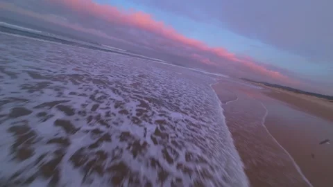 Low-angle drone shot captures ocean waves meeting shore Stock Footage 344543608