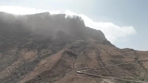 Low-angle drone shot of clouds rolling over the volcanic ridges of Monte Verde Stock Footage 334637054