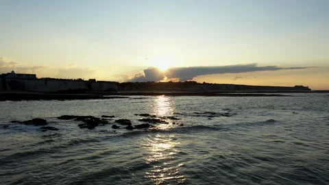 Low angle drone shot flying over the waves towards the beach at sunset. Stock Footage 146743376