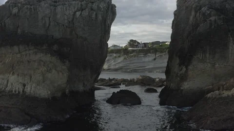 Low angle drone shot going through cliffs with a fisherman during sunrise 4k Stock Footage 137708427