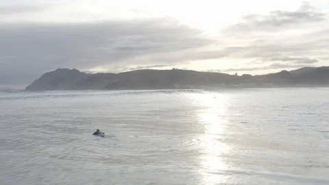 Low angle drone shot of waves and surfers in Spain Stock Footage 126353757