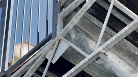 Low angle dynamic shot of a metal fire escape ladder and railing leading up.. Stock Footage 337718194
