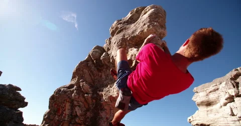 Low angle of extreme free climbing man hanging on rock Vidéo 61413071
