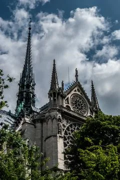 A low angle of the facade of Notre Dame de Paris in France against a cloudy d 스톡 사진