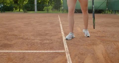 Low angle faceless sportswoman warming up before tennis match hitting the ball Stock Footage 157150950