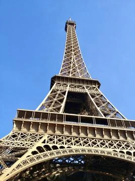 Low angle of the famous Eiffel Tower in Paris, France under a clear blue sky Photos