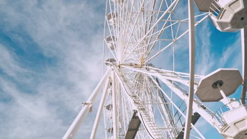 Low angle Ferris wheel. Amusement park wheel cabins in motion. Summer Funfair Stock Footage 244210537