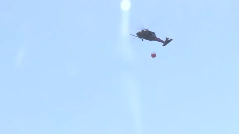 Low Angle of First Aid Helicopter Flying out Carrying a Bambi Bucket Stock Footage 130589875