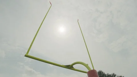 Low angle flags waving in air on goalpost in American football stadium Stock Footage 104768719