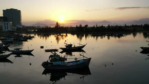 Low angle flying across piers and fishing boats revealing sunset Stock Footage 147983295
