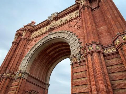 Low angle frontal view the red Arc de Triomf. Stock Photos