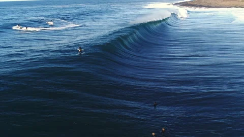 Low Angle of Glowing Lip with Surfers Waiting Beyond Wave Pattern, Wide View Stock Footage 310645338