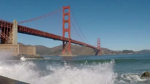 Low Angle Golden Gate Bridge with Waves Crashing in Foreground Stock Footage 244276087