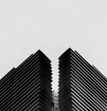 Low angle grayscale shot of angular modern buildings 스톡 사진