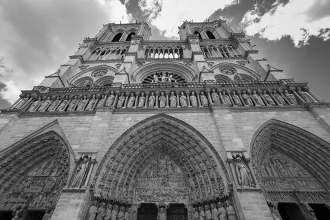 Low angle grayscale shot of Notre-Dame in Paris, France under a cloudy sky Photos