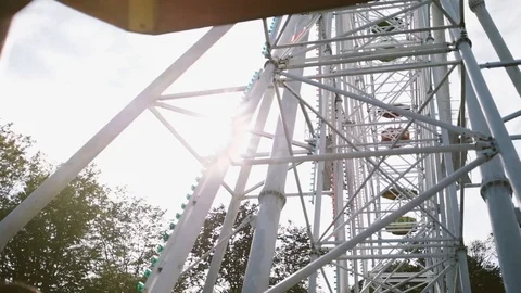 Low angle handheld shot of Ferris wheel at amusement park ride against sky Stock Footage 122519619