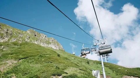 Low angle handheld shot of tourist travelling on ski lift against sky Stock Footage 122406189