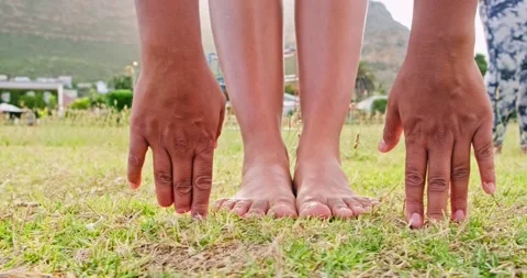 Low angle, hands, feet and grass. Touching toes for stretching and exercise. Stock Footage 307840737