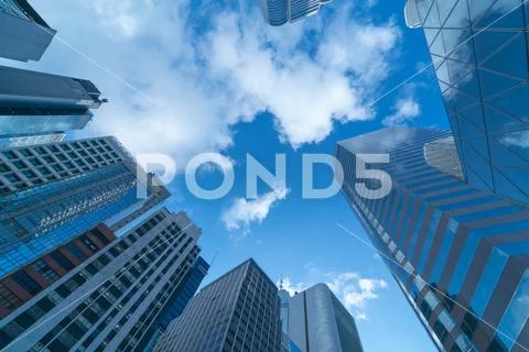 View of high rise glass office building on blue sky background