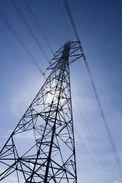 Low angle of a high-voltage tower under a clear blue sky background Stock Photos
