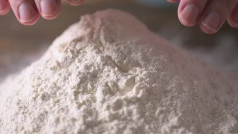 Low angle of home chef hands creating well in mound of flour in slow motion  Stock Footage 171484873