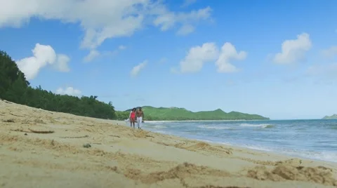 Low angle hot couple holding hands at the beach slow motion 動画素材 63355289