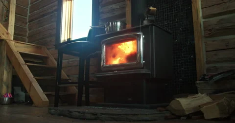 Low angle interior of small log cabin fireplace stove Stock Footage 156587885