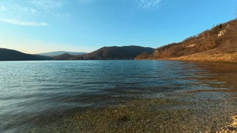 Low-Angle Lake Shot – Calm Water with Slightly Different Distant View, Autumn Video stock 330989029