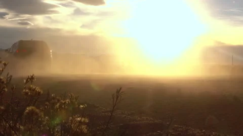 LOW ANGLE: Large SUV raises dust while driving down empty road in New Mexico. Stock Footage 157270920