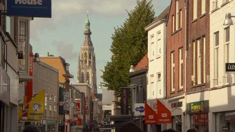 Low angle lockdown shot of historic Grote Kerk tower amidst buildings in city Video stock 129232191