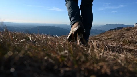 Low angle locked down shot of a female hiker walking past on a mountain path Stock Footage 124893463