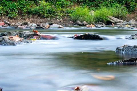 A Low Angle Long Exposure Of a Stream Full of Multicolored Rocks Stock Photos