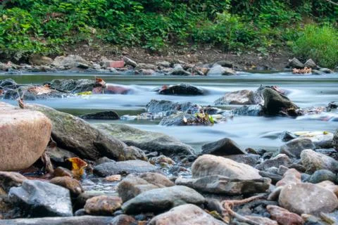 A Low Angle Long Exposure Of a Stream Full of Multicolored Rocks Stock Photos
