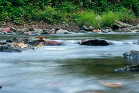 A Low Angle Long Exposure Of a Stream Full of Multicolored Rocks Stock Photos