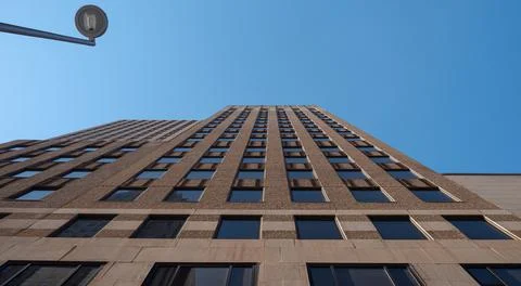 Low angle looking up the face of a building against clear blue sky Stock Photos