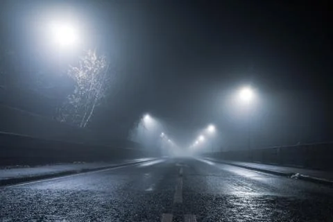 Low angle, looking up at a road and street lights on an atmospheric night Stock Photos